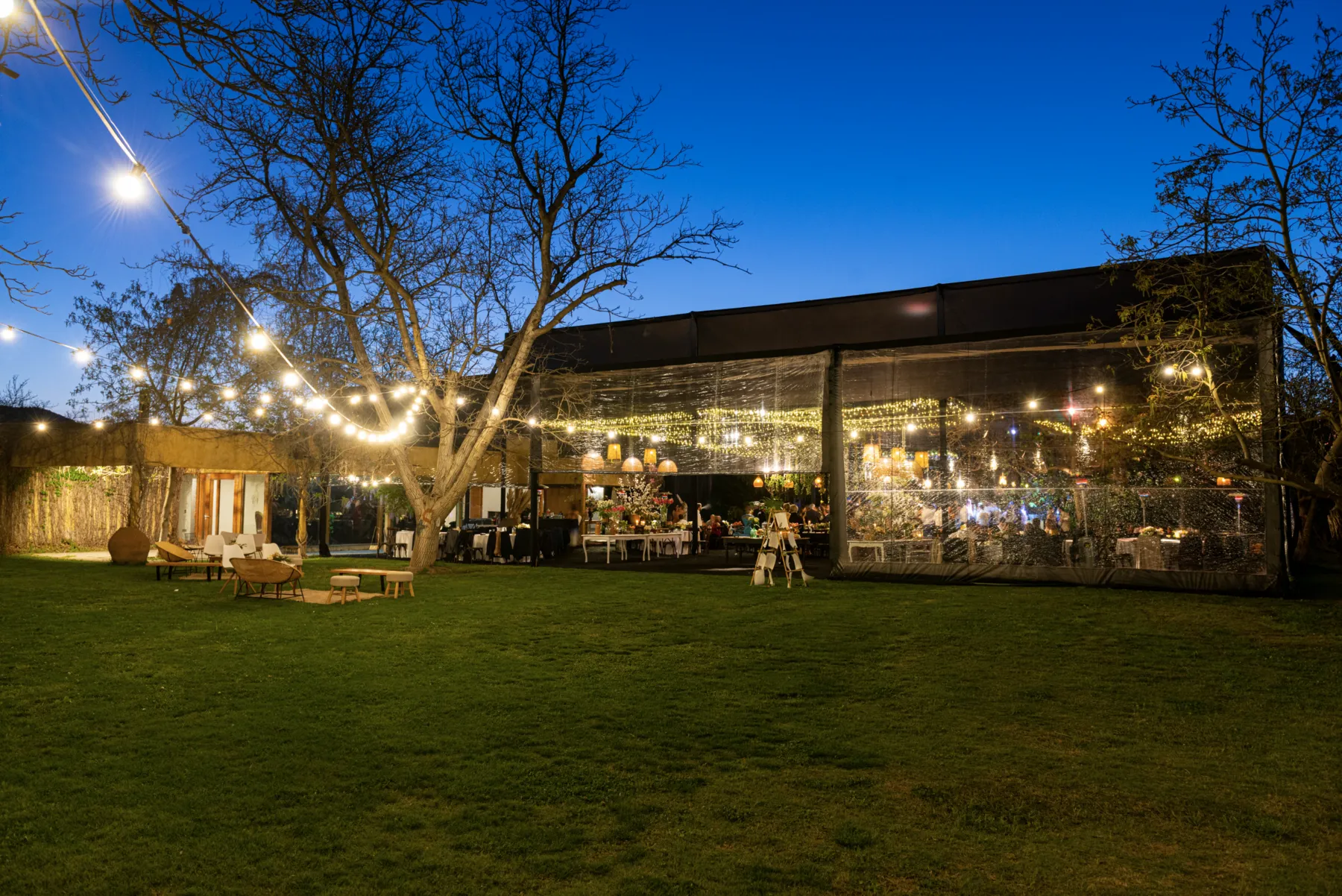 Bracco Viña Boutique de noche, con el jardín y el salón iluminados