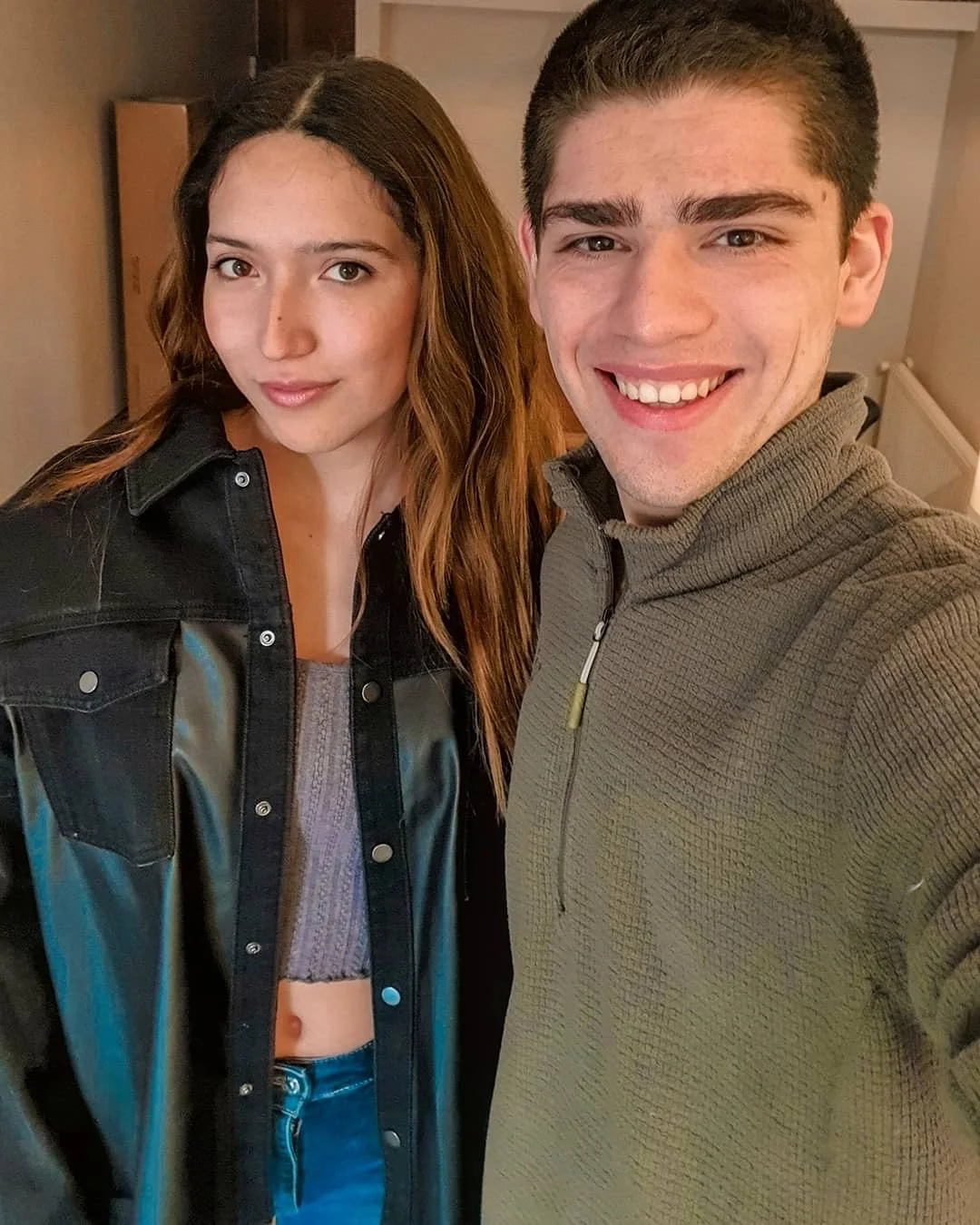 Isi con una chaqueta negra y Max con un suéter verde al comienzo de su relación
